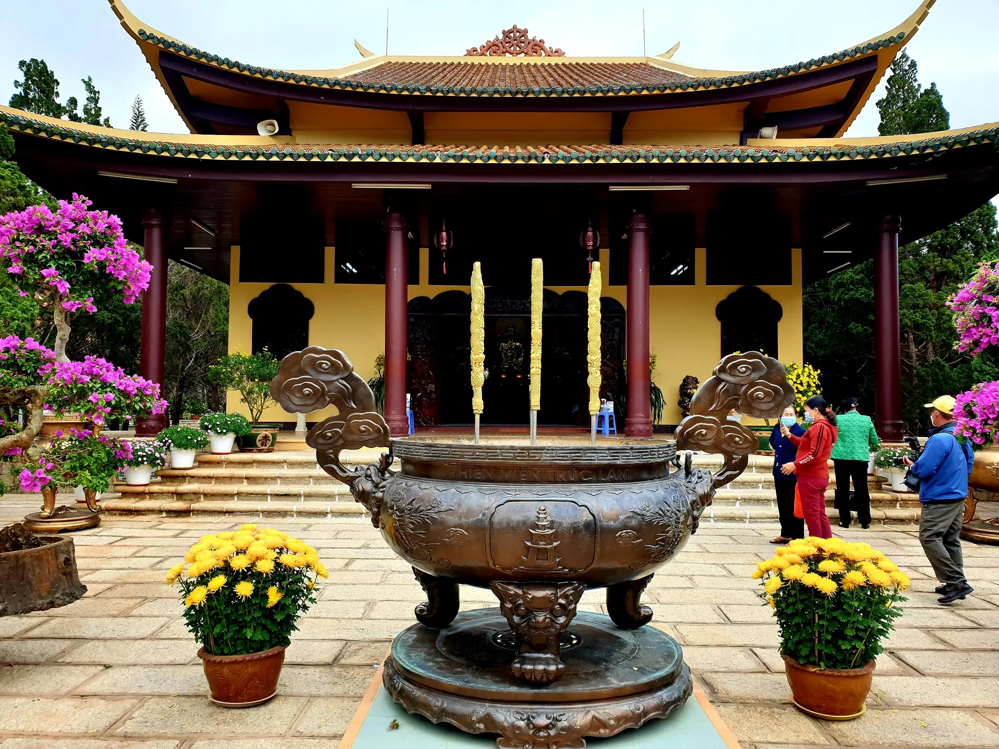 Chánh điện Thiền viện Trúc Lâm Đà Lạt, phía trước là lư hương đồng giữa hai chậu cúc vàng