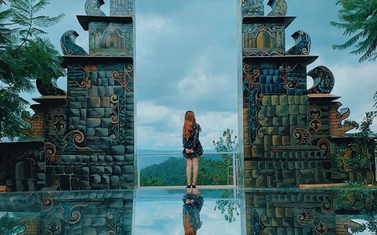 Cô gái đứng giữa khung Cổng Trời Bali nhìn ra đồi thông xanh phía xa