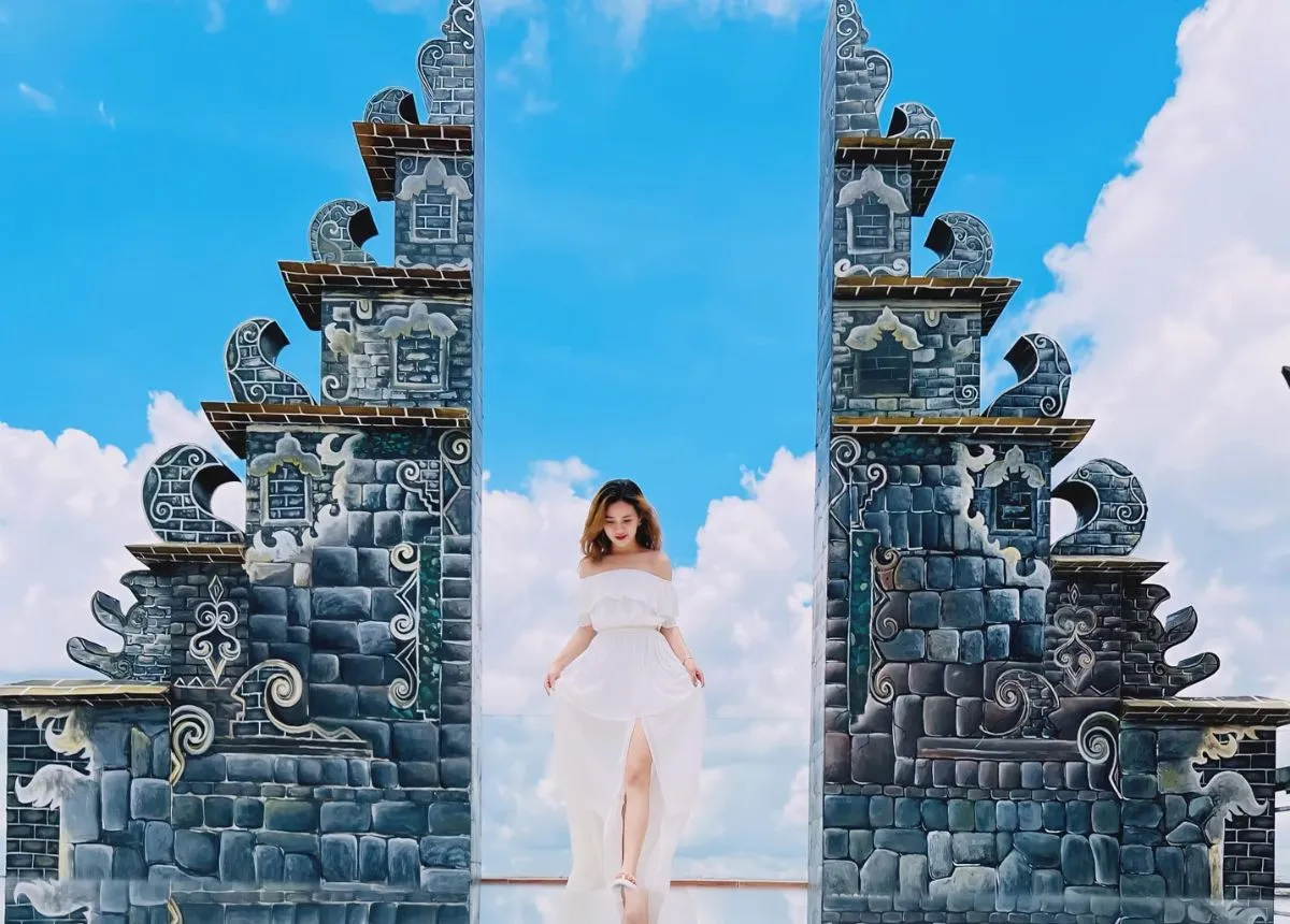 Cô gái váy trắng bước giữa Cổng Trời Bali dưới trời xanh mây trắng