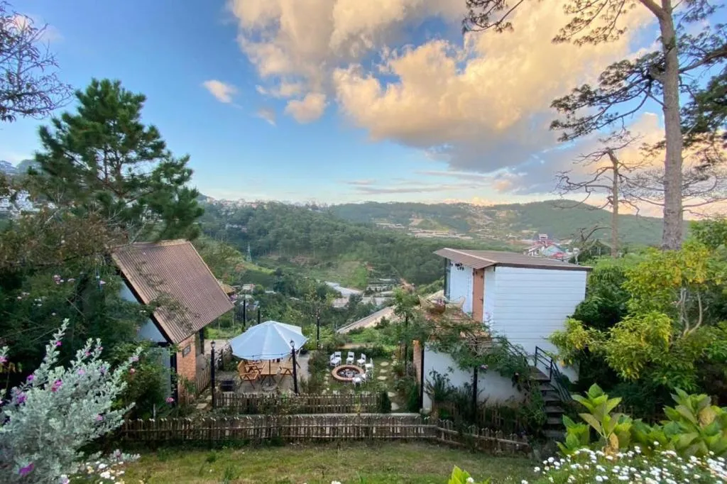 Homestay trên đồi thông Đà Lạt với sân vườn, ô che và bếp lửa, nhìn ra thung lũng lúc hoàng hôn