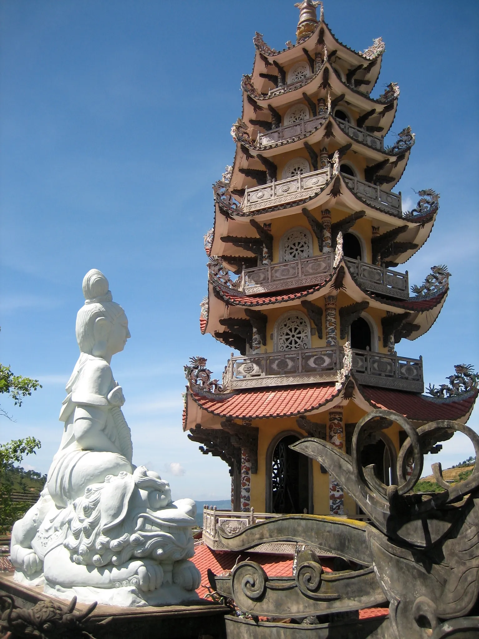 Tháp chuông Linh Pháp nhiều tầng của chùa Linh Phước, bên cạnh tượng Quan Âm